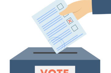 Hand putting voting bulletin in box